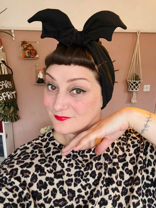 Woman wears black bat headband 